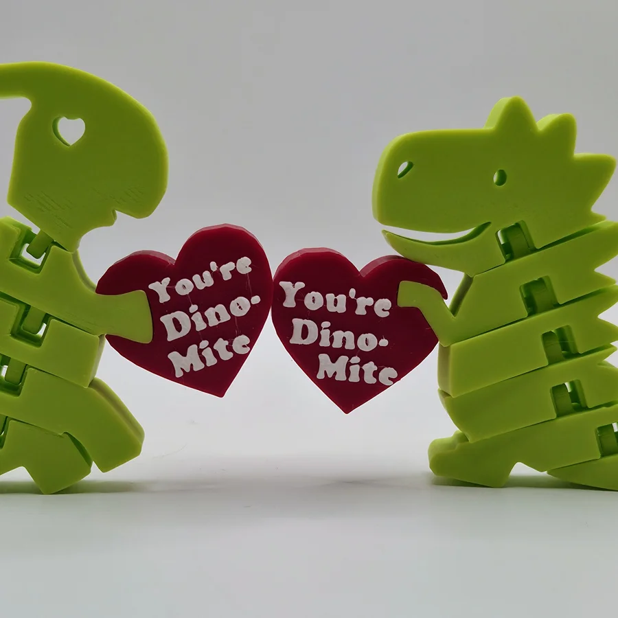 Two articulated dinosaurs holding You're Dino-Mite hearts